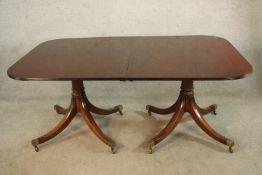 A 19th century mahogany extending twin pillar dining table with two additional leaves, the turned