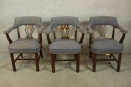 A set of three 20th century mahogany framed open arm and pierced splat back chairs raised on
