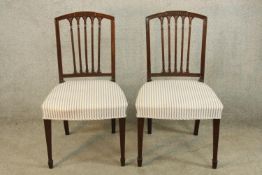 A pair of 19th century Sheraton style mahogany framed dining chairs with cream upholstered stuffover