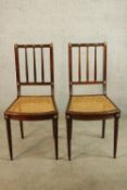 A pair of 19th/early 20th century cane seated and bar backed bedroom chairs each raised on turned