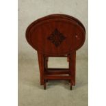 A set of three 20th century mahogany oval topped folding tables with leaf decoration. H.80cm.