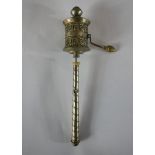 A 20th century polished pewter Tibetan prayer wheel, opening to reveal the original prayer. H.22 W.4