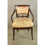 A 19th century mahogany framed upholstered back and seat open armchair on outswept supports.