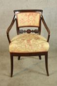 A 19th century mahogany framed upholstered back and seat open armchair on outswept supports.