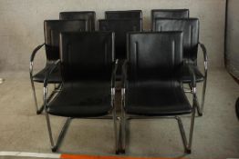 A set of eight contemporary black leather and chrome framed open arm chairs, raised on tubular