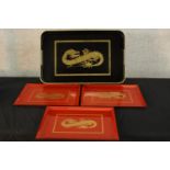 A set of three red lacquer trays, each decorated with a gold painted dragon, together with a Chinese