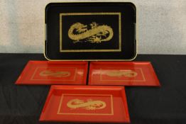 A set of three red lacquer trays, each decorated with a gold painted dragon, together with a Chinese