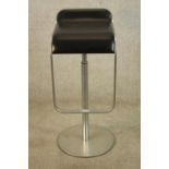A contemporary brushed steel and black leather adjustable bar stool. H.83cm.
