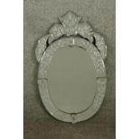 A late 19th/early 20th century Venetian style glass oval wall hanging mirror with incised floral