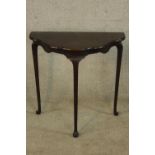 An early 20th century mahogany shaped hall table raised on tapering cabriole supports terminating in