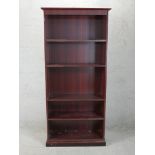 A contemporary mahogany effect floor standing open bookcase raised on plinth base. H.184 W.86 D.35cm