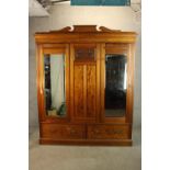 A late 19th/early 20th century pitch pine three door wardrobe, with two mirror doors above two