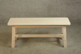 A contemporary limed beech bench raised on four splayed supports with cross stretcher. H.46 W.103cm.