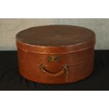 An early 20th century circular textured leather hat box with carrying handle. H.22 Dia.45cm.
