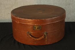 An early 20th century circular textured leather hat box with carrying handle. H.22 Dia.45cm.