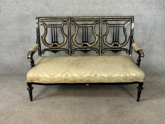 A 19th century ebonised and mother of pearl three seater pierced splat back open arm settee raised