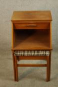 A mid 20th century teak telephone table with integral sliding seat, raised on square supports. H.