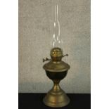 An early 20th century brass oil lamp with clear glass chimney. H.56cm.