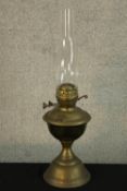 An early 20th century brass oil lamp with clear glass chimney. H.56cm.