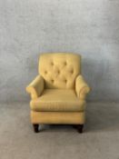 A 19th century button back yellow upholstered armchair raised on turned supports. H.90cm