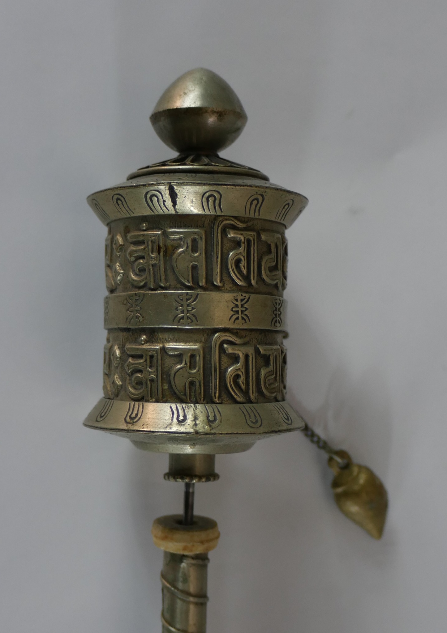 A 20th century polished pewter Tibetan prayer wheel, opening to reveal the original prayer. H.22 W.4 - Image 2 of 3