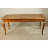 A 19th/early 20th century French beech single drawer kitchen table raised on shaped cabriole