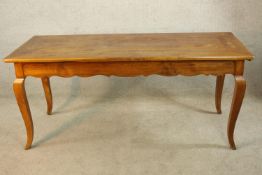 A 19th/early 20th century French beech single drawer kitchen table raised on shaped cabriole