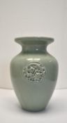 A Chinese green celadon crackle glaze baluster vase with incised mythical creature decoration. H.
