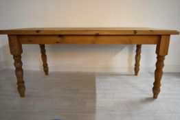 A rectangular pine farmhouse style kitchen table raised on turned supports. H.77 W.183 D.92cm