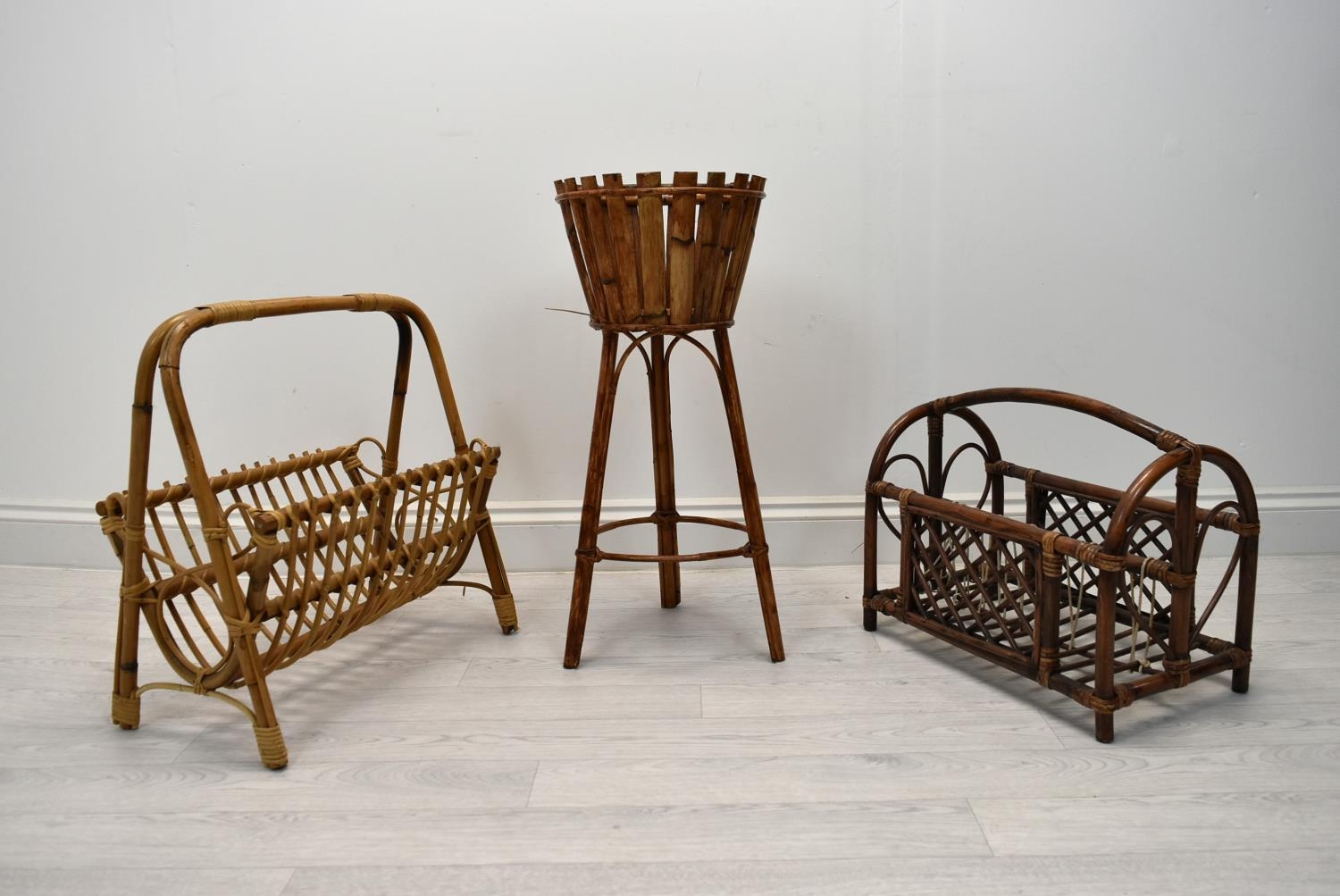 Two mid 20th century bamboo magazine stands together with a mid 20th century wicker plant stand