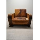 A walnut framed Art Deco leather armchair, the arms and back with integrated shelves. H.86.5 W.111.5