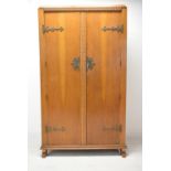 An early 20th century Gothic style carved mahogany twin door wardrobe with brass strapwork hinges
