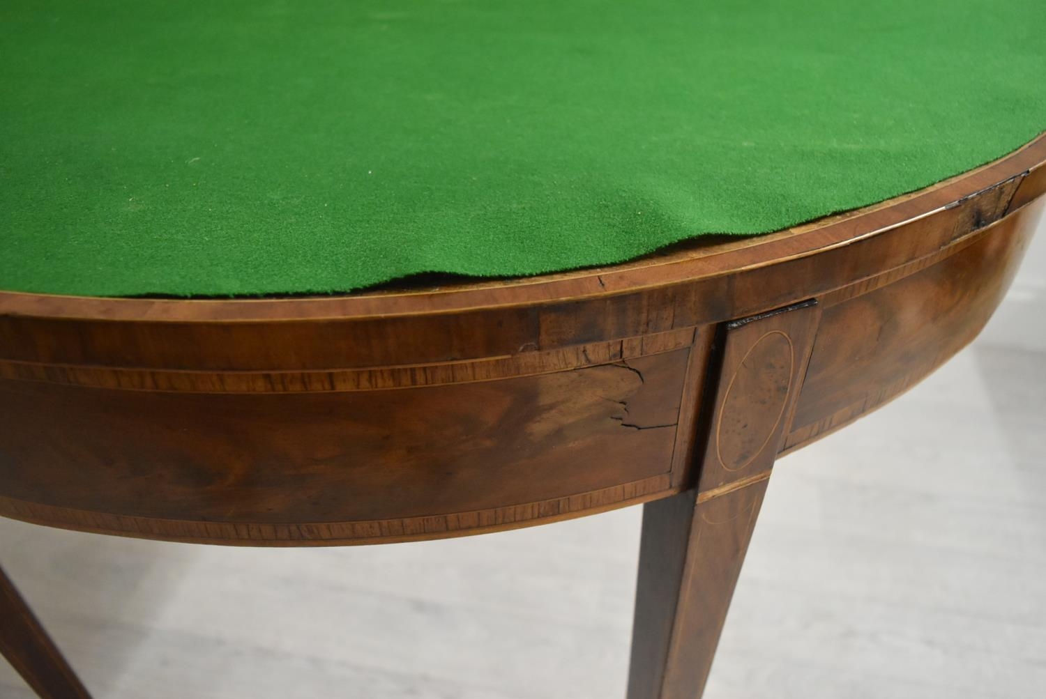 A George III cross banded mahogany fold over demi lune games table, raised on square tapering - Image 5 of 12