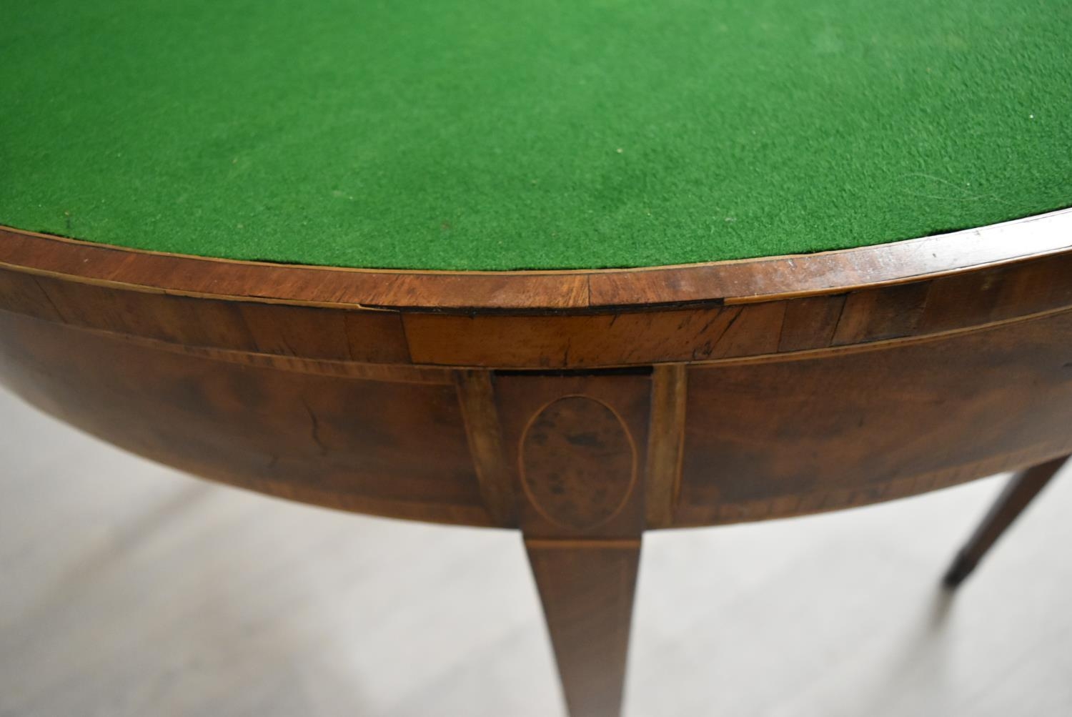 A George III cross banded mahogany fold over demi lune games table, raised on square tapering - Image 9 of 12