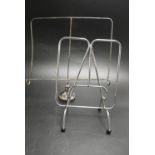 A silver plated modernist magazine rack raised on pad feet together with a chrome plated magazine