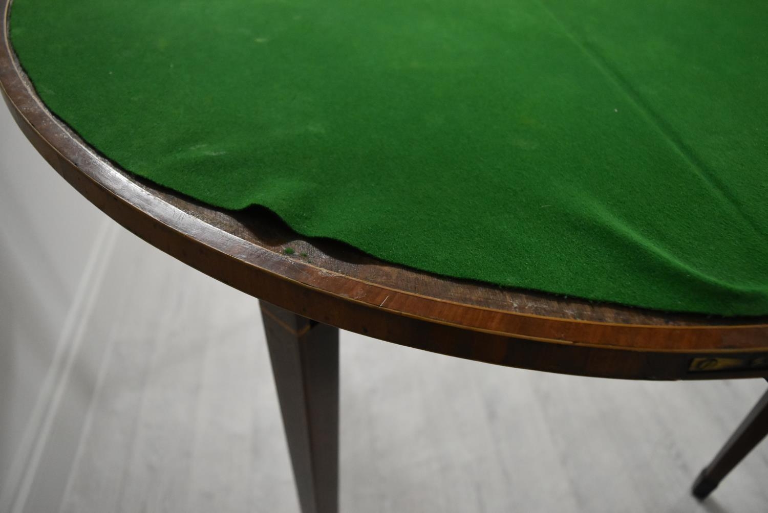 A George III cross banded mahogany fold over demi lune games table, raised on square tapering - Image 10 of 12