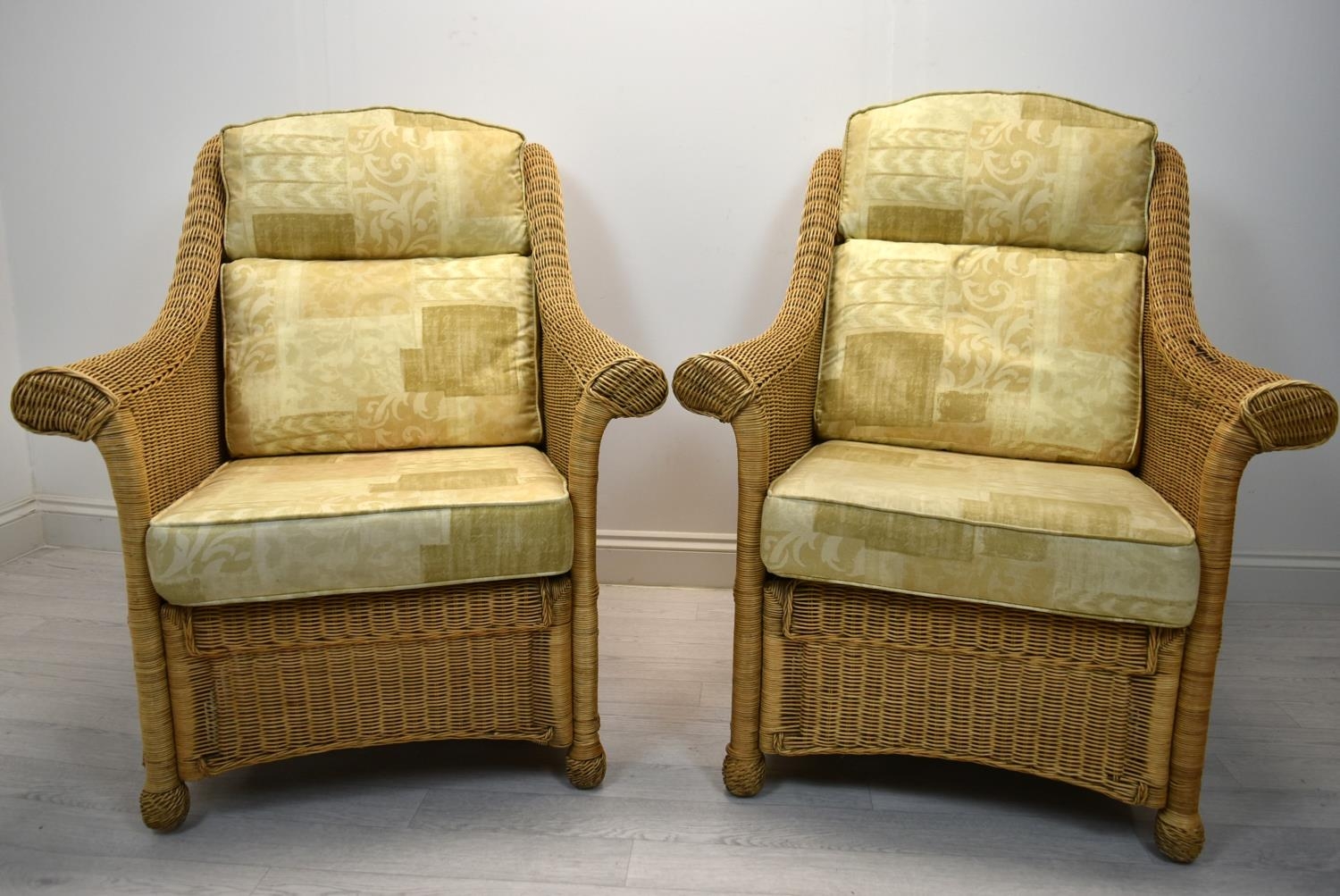 A pair of contemporary cane conservatory armchairs each with loose cushions. H.98 W.82cm