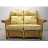 A contemporary wicker two seater conservatory sofa with four loose cushions. H.98 W.135 D.63cm