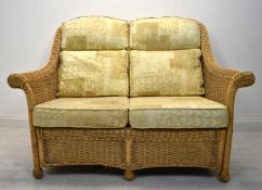 A contemporary wicker two seater conservatory sofa with four loose cushions. H.98 W.135 D.63cm