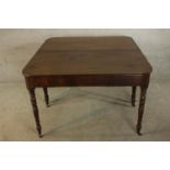 A George III mahogany D end dining table raised on turned supports terminating in brass casters. H.