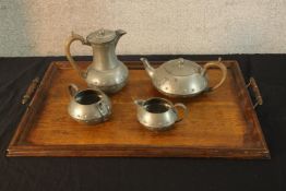 An Arts & Crafts English hammered pewter four piece tea and coffee set, together with an oak twin