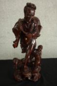 An early 20th century carved Chinese hardwood figure of a fisherman and a child, raised on