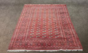 A red ground Persian carpet with all over geometric patterns.H.283 x W.310 cm.