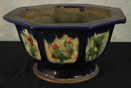 A 20th century Chinese pottery octagonal shaped garden planter decorated with panels of flowers