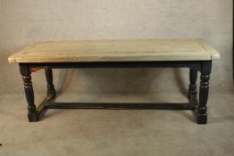 A 19th century painted and scrubbed pine refectory table raised on turned supports with central H