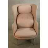 A mid 20th century Pink winged back armchair raised on splayed metal legs. H.112 x W.80 cm.