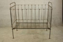 A 19th century brass sided childs bed/cot raised on cylindrical supports terminating in pad feet.