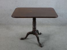 A 19th century mahogany rectangular tilt top table with turned central column raised three