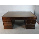 A 20th century stained mahogany twin pedestal partners desk with brass swing handles raised on