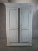 A 20th century French painted pine twin door armoire raised on shaped feet. H.222 W.150 D.63cm